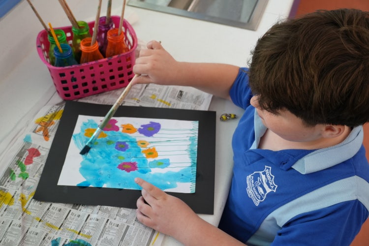 student painting at desk