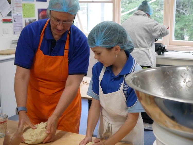 student with teacher during cooking class