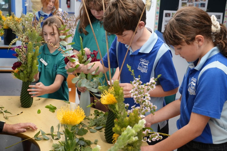 3 students making floral arrangements