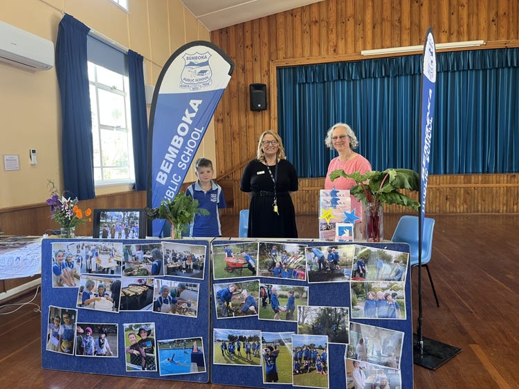 student, teacher and SLSO at school stand at local hall community ub