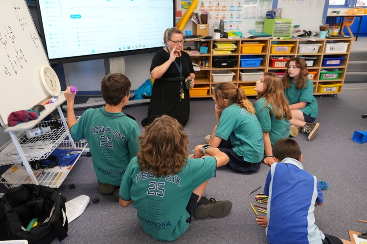 teacher working with students on the floor