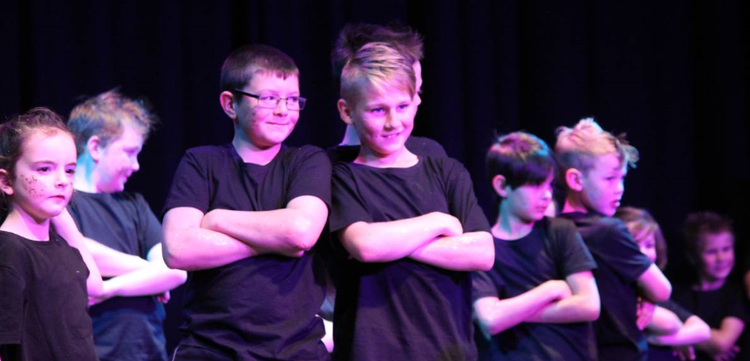 students performing dance ensemble on stage