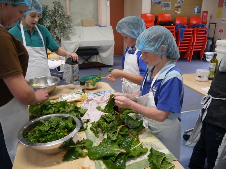 students preparing garden produce in the kitchen