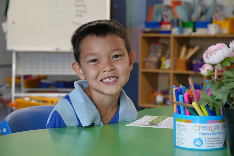 student sitting at desk smiling