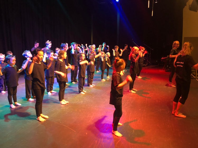 students rehearsing dance ensemble on stage